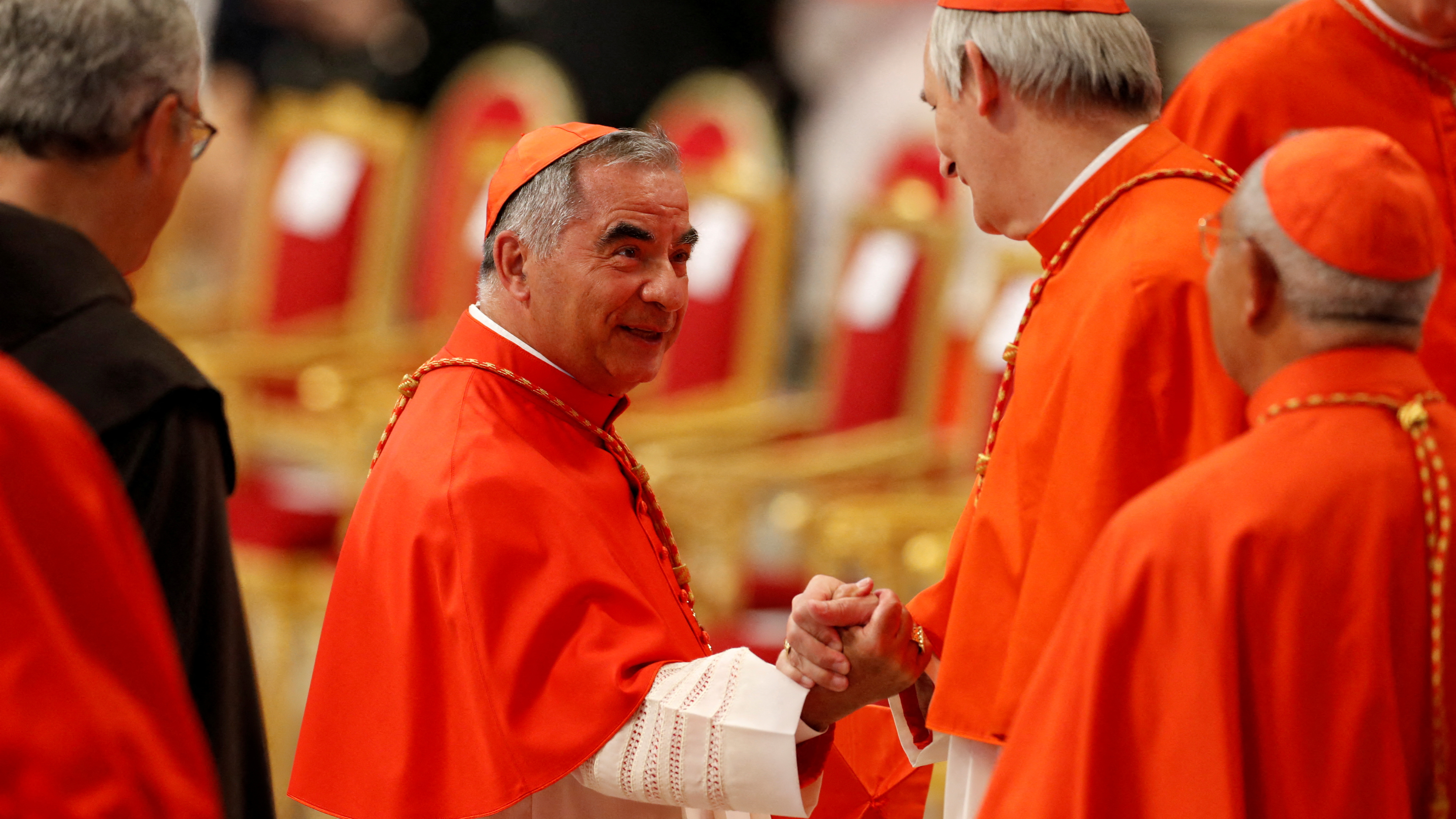 O cardeal Angelo Becciu saúda o cardeal Matteo Zuppi na Basílica de San Pedro. REUTERS/Remo Casilli/Arquivo