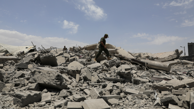 Un policía camiña sobre os cascotes dun edificio destruído polos ataques dos EUA en Sanaa, Iemen. (REUTERS/Khaled Abdullah)