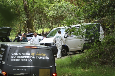 A Garda Civil investiga o achado do coche calcinado, descuberto por uns sendeiristas no lugar de Caneda (EFE/ Xoán Rey)