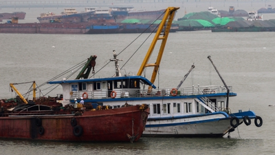 O barco turístico (branco) chega remolcado a porto. REUTERS/Thinh Nguyen