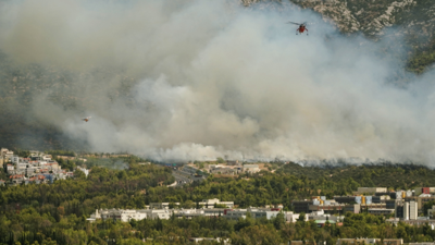 Helicópteros de extinción de incendios sobrevoan un incendio forestal en Atenas/Stamos Prousalis/Reuters