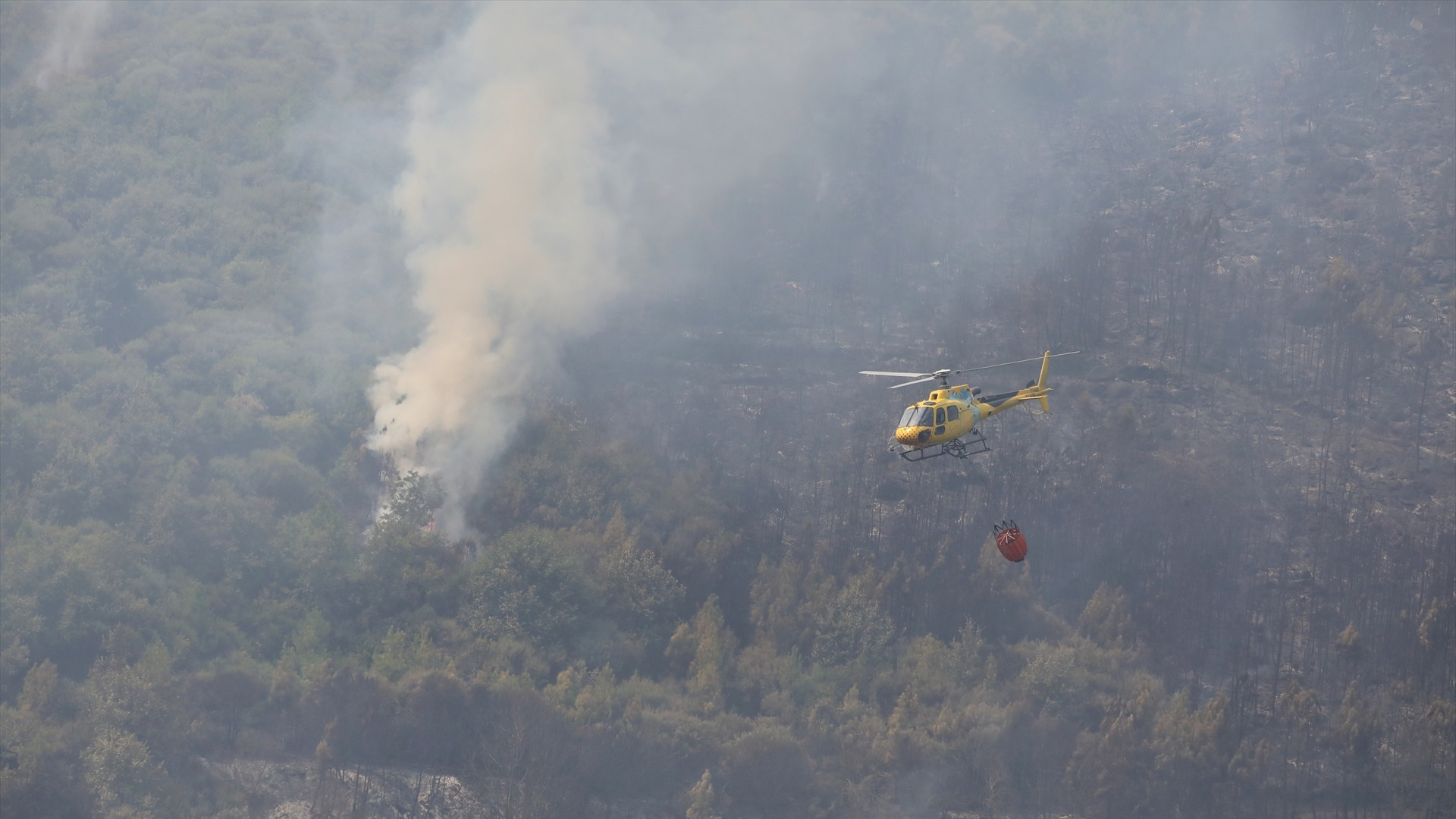 Un helicóptero tira auga sobre a zona do incendio en Cuevas del Valle, Ávila (Foto de arquivo/Juanma Jiménez/Europa Press)