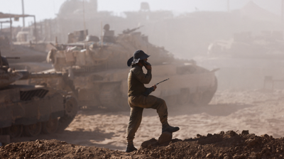Un soldado israelí atópase xunto a vehículos militares vistos desde o lado israelí da fronteira entre Israel e Gaza (Amir Cohen/Reuters)