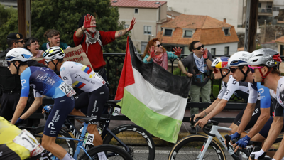Os ciclista do equipo Israel Premier Tech pasan ante as protestas propalestina/ Lavandeira Jr/EFE