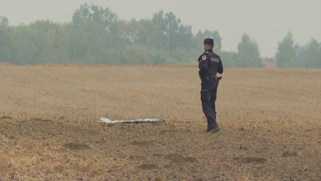 Imaxe dun dos drons caídos en territorio polaco, custodiado por un policía (Reuters)