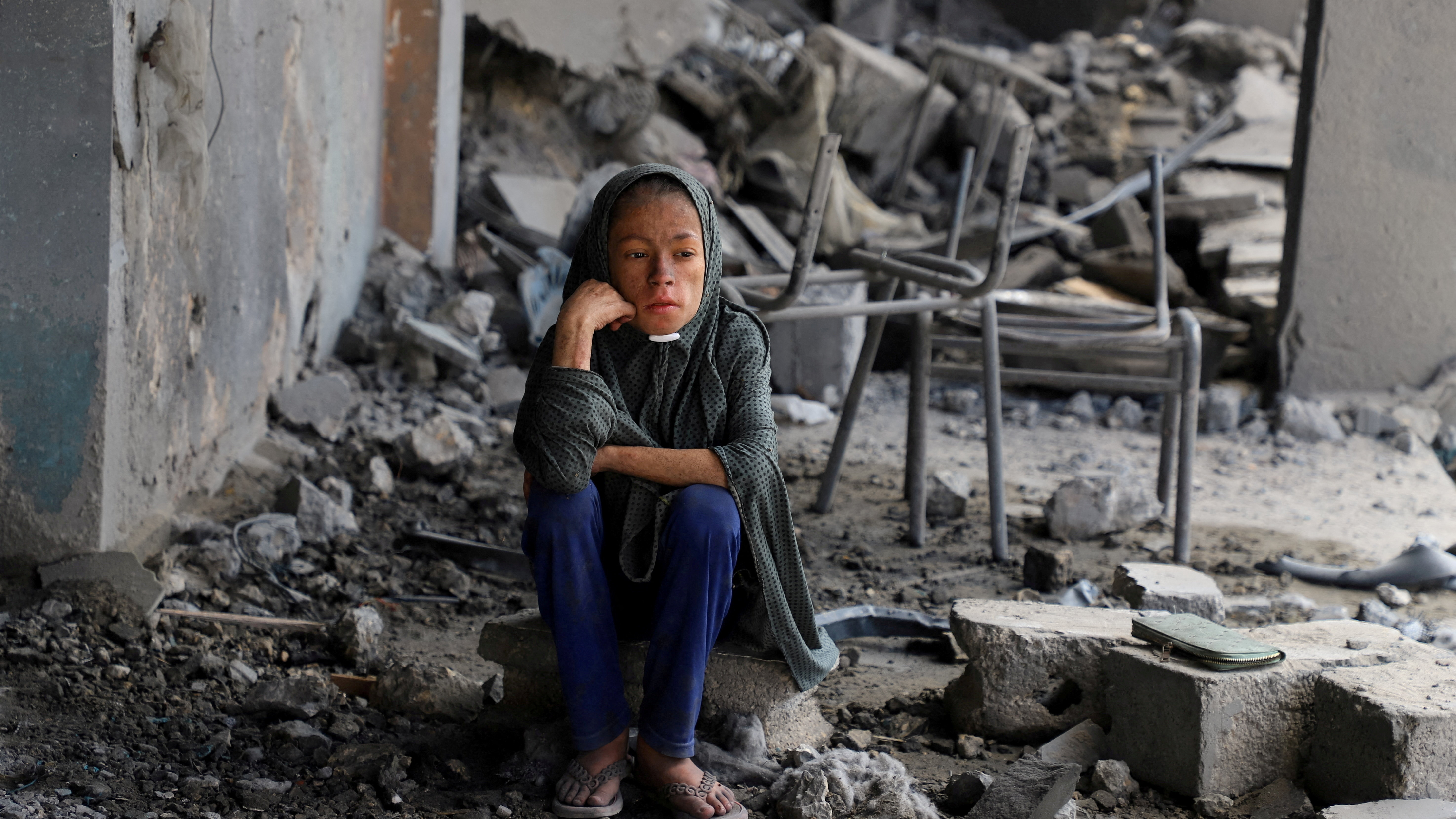 Unha nena palestina senta entre os cascallos dun refuxio bombardeado polos israelís a pasada noite. REUTERS/Ebrahim Hajjaj