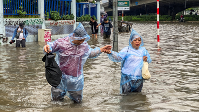 A xente camiña por unha rúa asolagada no medio de fortes chuvieiras provocadas polo tifón Matmo, que deixou vehículos varados, pechou escolas e atrasou voos en Hanoi (REUTERS / Thinh Tien Nguyen)