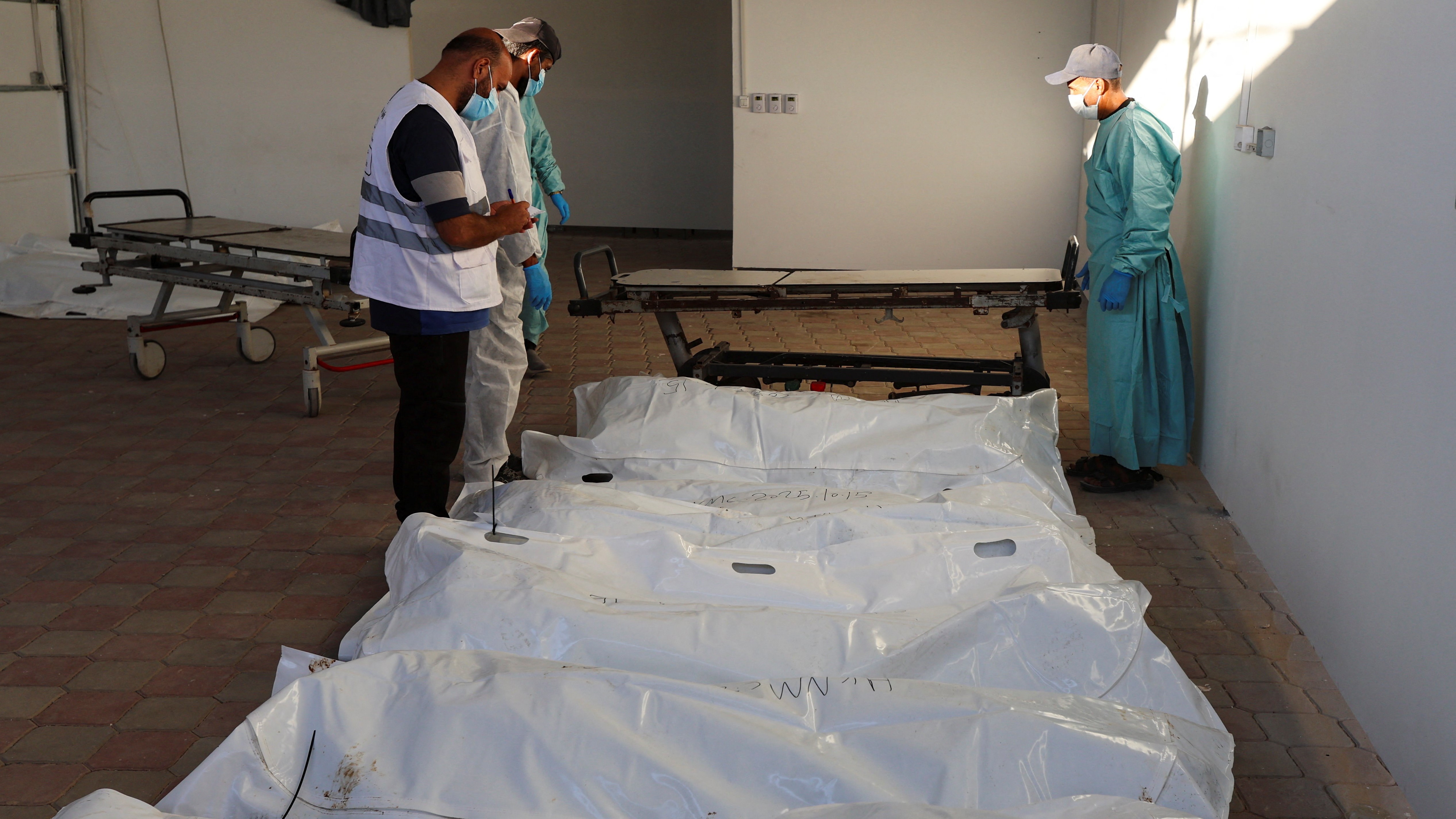 Un equipo médico palestino identifica corpos entregados por Isarael. REUTERS/Ramadan Abed
