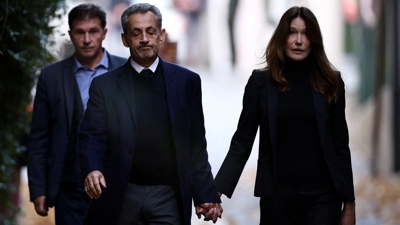 Nicolas Sarkozy da man da súa dona Carla Bruni saíndo do seu domicilio camiño da prisión (Reuters/Sarah Meyssonnier)