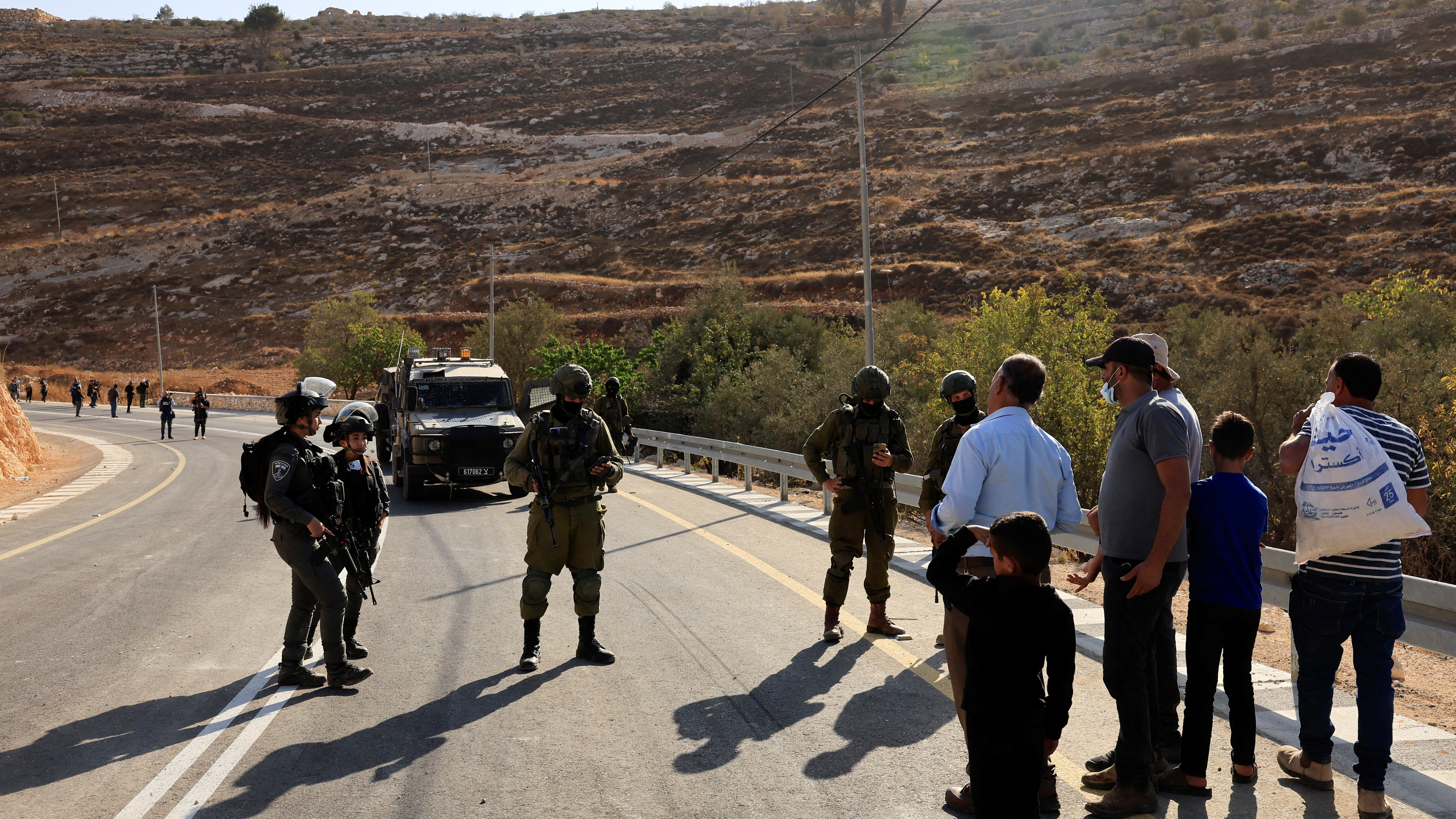 Soldados israelís impiden aos agricultores entrar aos seus terreos para recoller as olivas. REUTERS/Mussa Qawasma.