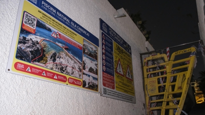 Imaxe do acceso á piscina, con carteis que avisan do perigo