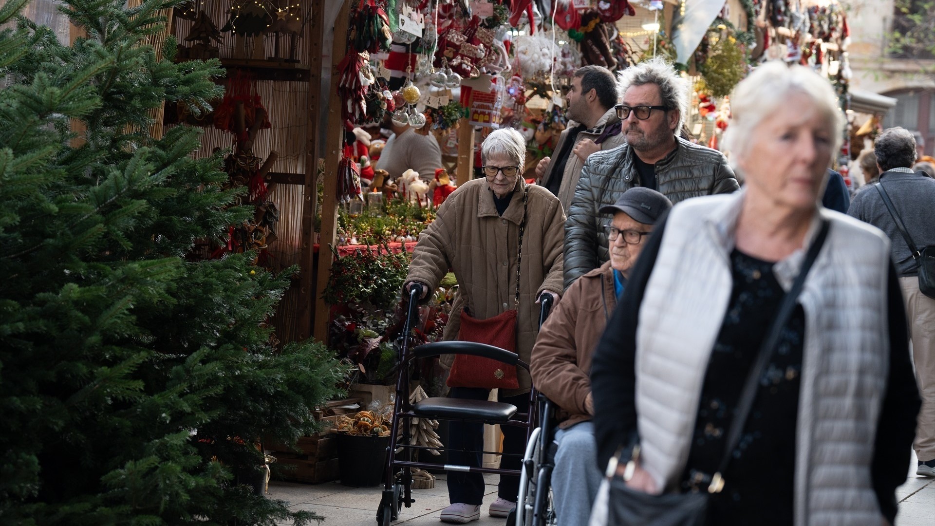 Varias persoas paseando entre os postos dun mercado de Nadal-Arquivo (Europa Press/David Zorrakino)