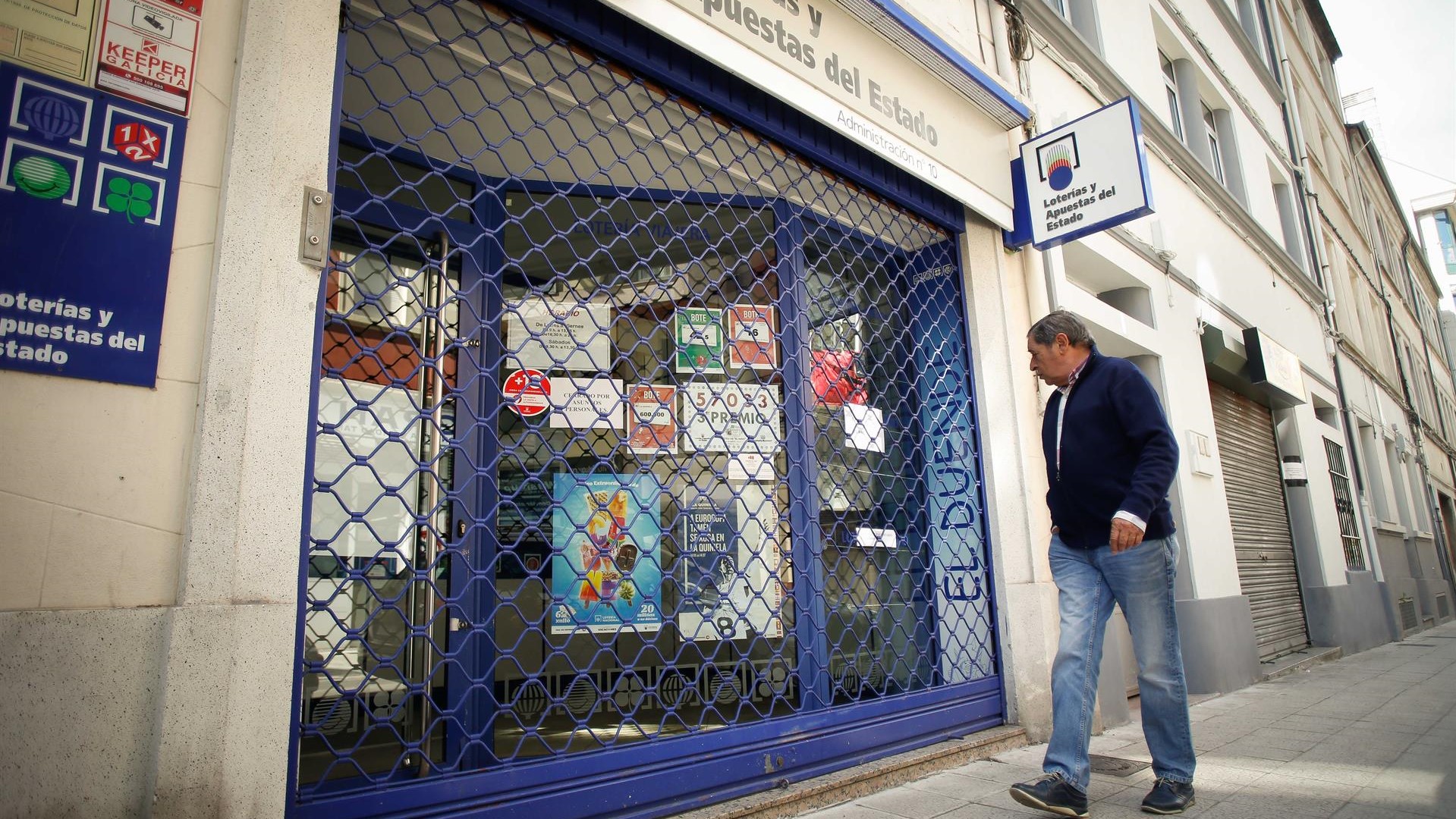 Imaxe de arquivo dun home lendo un cartel que indica que a qdministración de loterías nº 10 está pechada por asuntos persoais, despois de que detiveran o loteiro, 12 de xuño de 2024, en Lugo, Galicia (España).  (Carlos Castro-Europa Press)