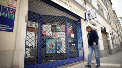 Imaxe de arquivo dun home lendo un cartel que indica que a Administración de loterías nº 10 está pechada por asuntos persoais, despois de que detivesen ao seu loteiro, 12 de xuño de 2024, en Lugo, Galicia (España).  (Carlos Castro - Europa Press)