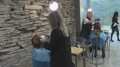 Varias clientas tinguen o pelo ao pé dun cubo da muralla de Lugo