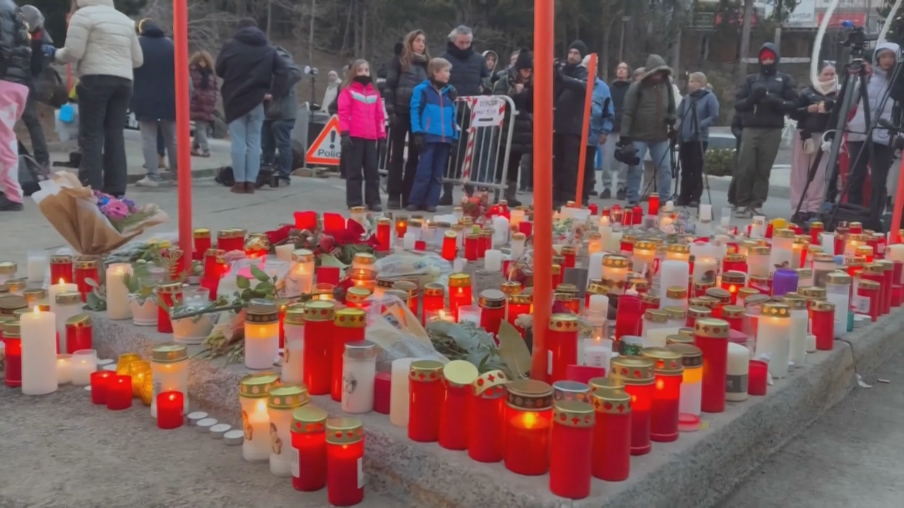 A xente deposita candeas nos arredores do bar suizo sinistrado, mentres a estación de esquí abre de novo as súas pistas