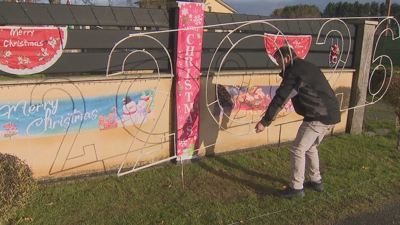 Un veciño de Outeiro de Rei retira o letreiro xigante para lle dar a benvida ao novo ano