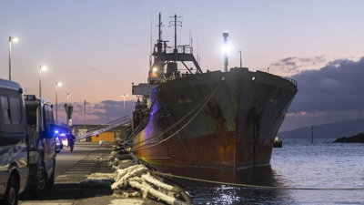 Efectivos policiais xunto ao buque intervido, o United S. no porto de Santa Cruz de Tenerife (EFE)
