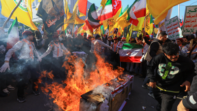 Manifestantes progubernamentais queiman bandeiras dos EUA e de Israel en Irán.  REUTERS/Thaier al-Sudani