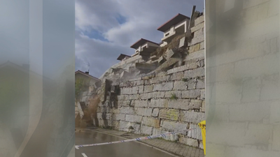 Momento no que cae o muro de pedra perpiaño que sostén unha urbanización en Barbadás