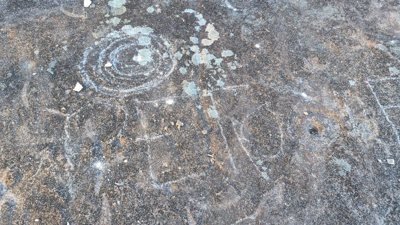 Danos nos gravados rupestres, que alguén raspou cunha pedra