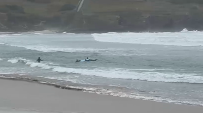 Imaxe do momento en que os surfeiros logran chegar a terra cos dous afectados