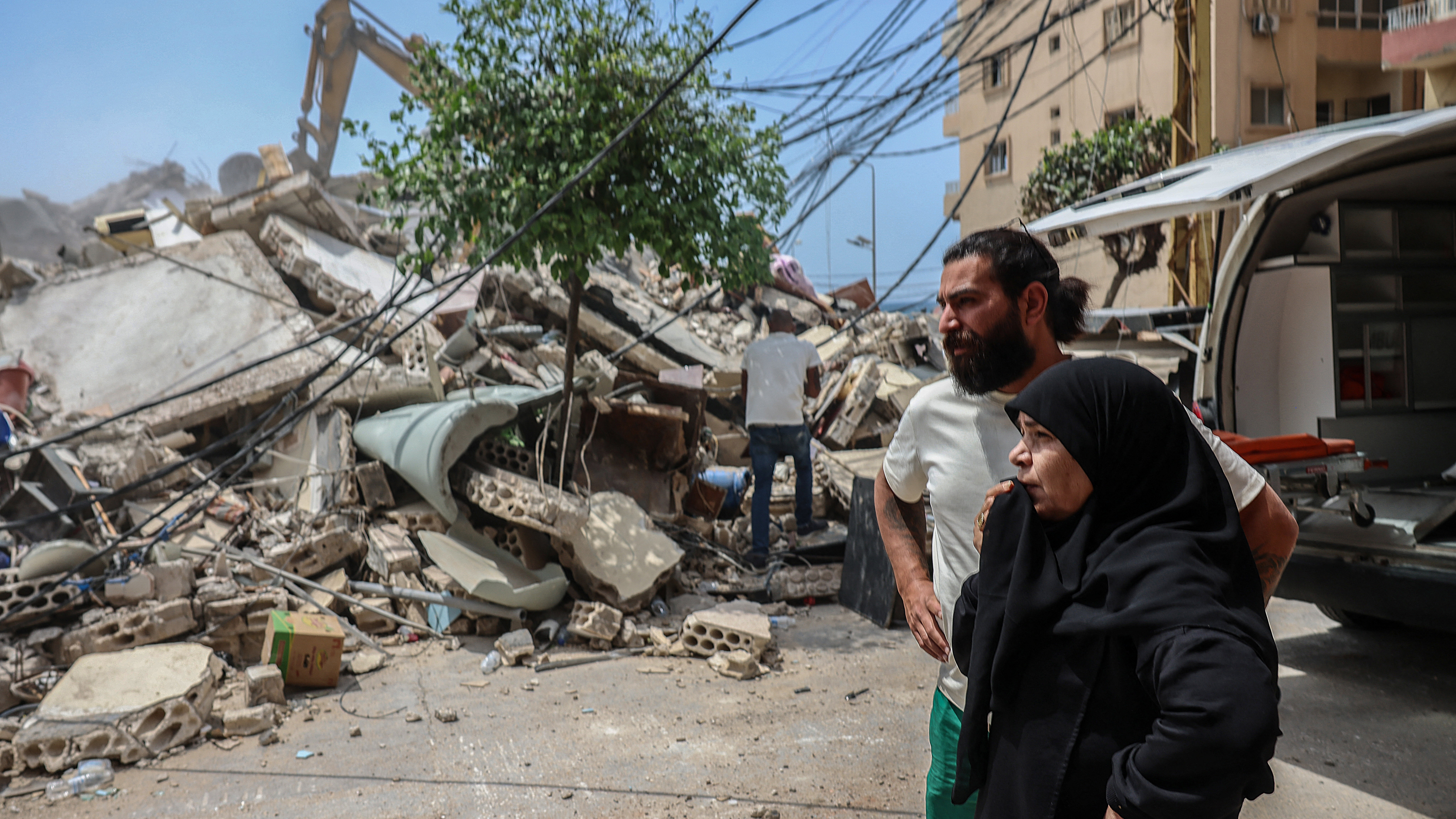 Unha parella observa o rescate de vítimas despois dun bombardeo israelí no Líbano. REUTERS/Louisa Gouliamaki.