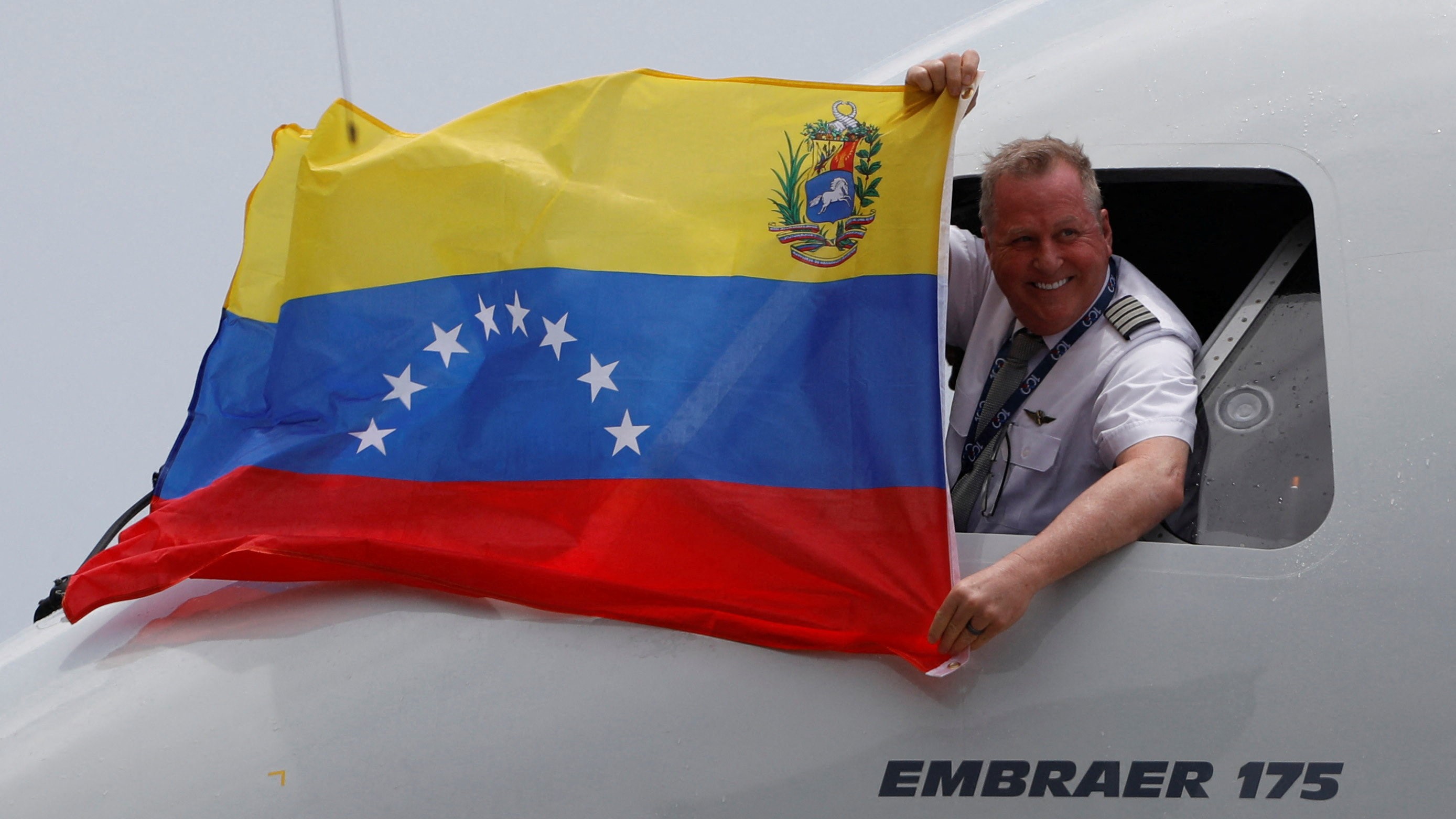O piloto do voo de American Airlines procedente de Miami amosa unha bandeira venezolana desde a cabina tras a aterraxe no aeroporto de Maiquetia (Reuters/Fausto Torrealba)
