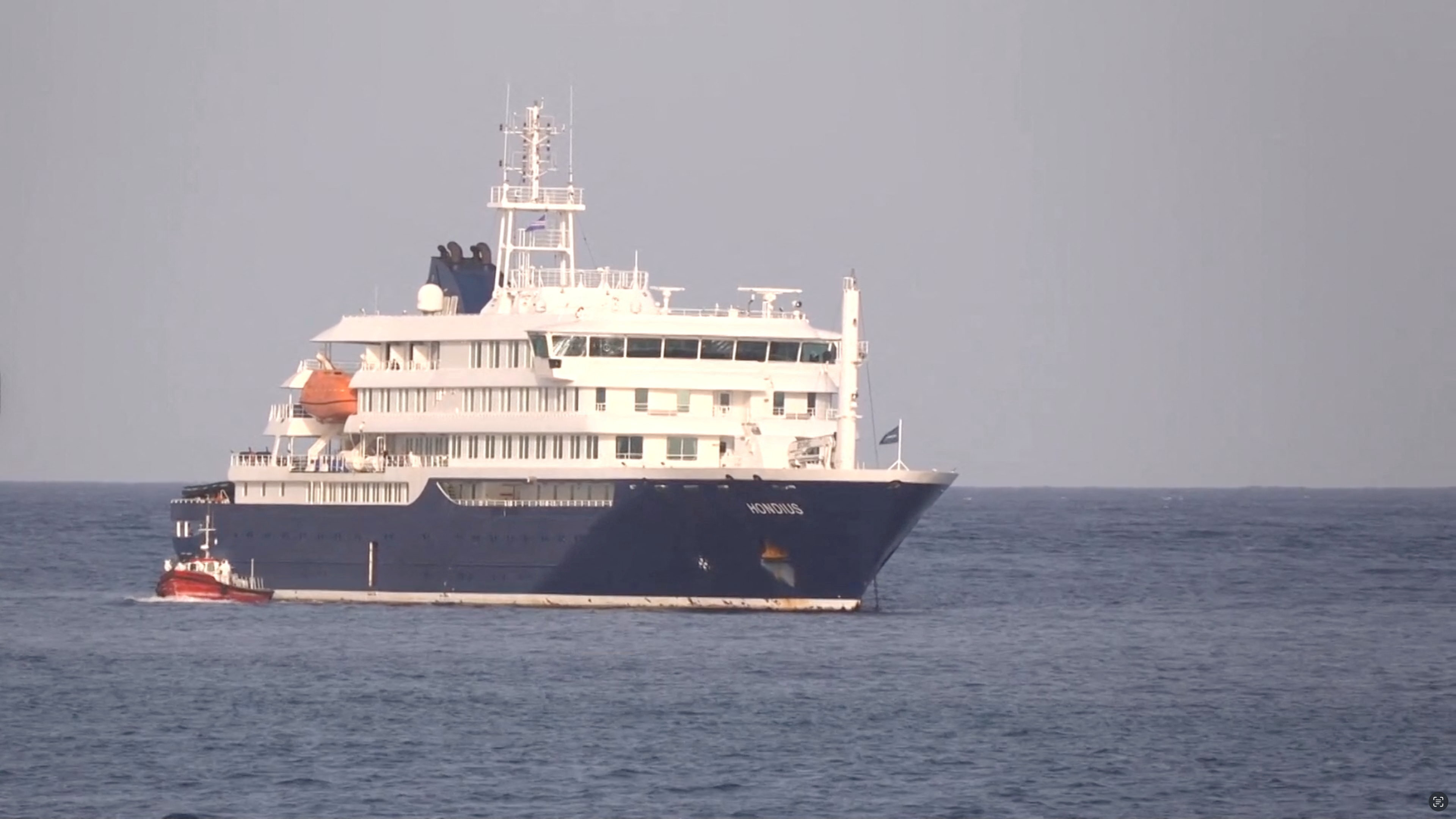 Un barco permanece xunto ao cruceiro fondeado fronte ao porto de Cabo Verde (REUTERS)