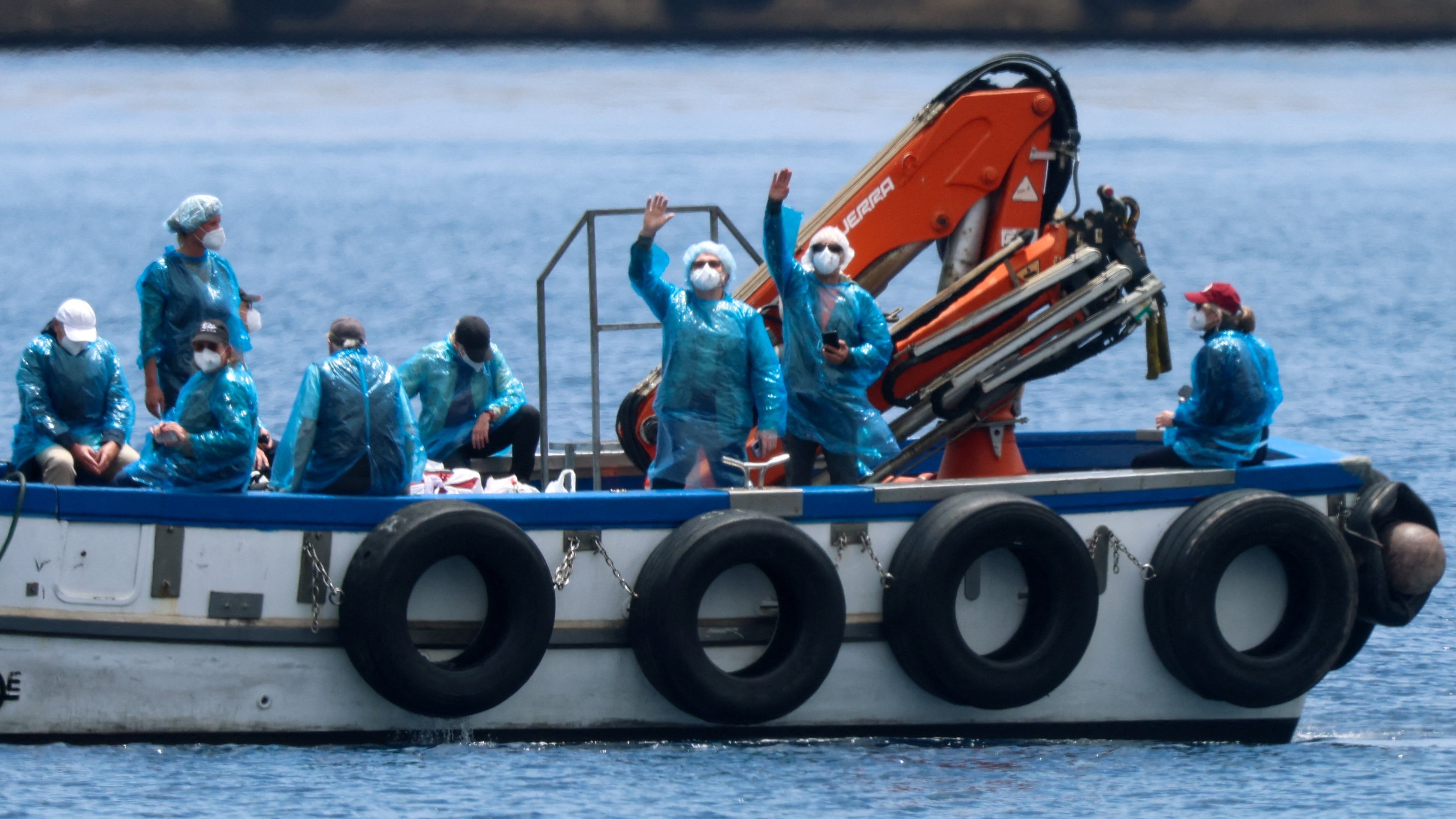 Varios pasaxeiros saúdan tras o desembarco. REUTERS/Hannah McKay.