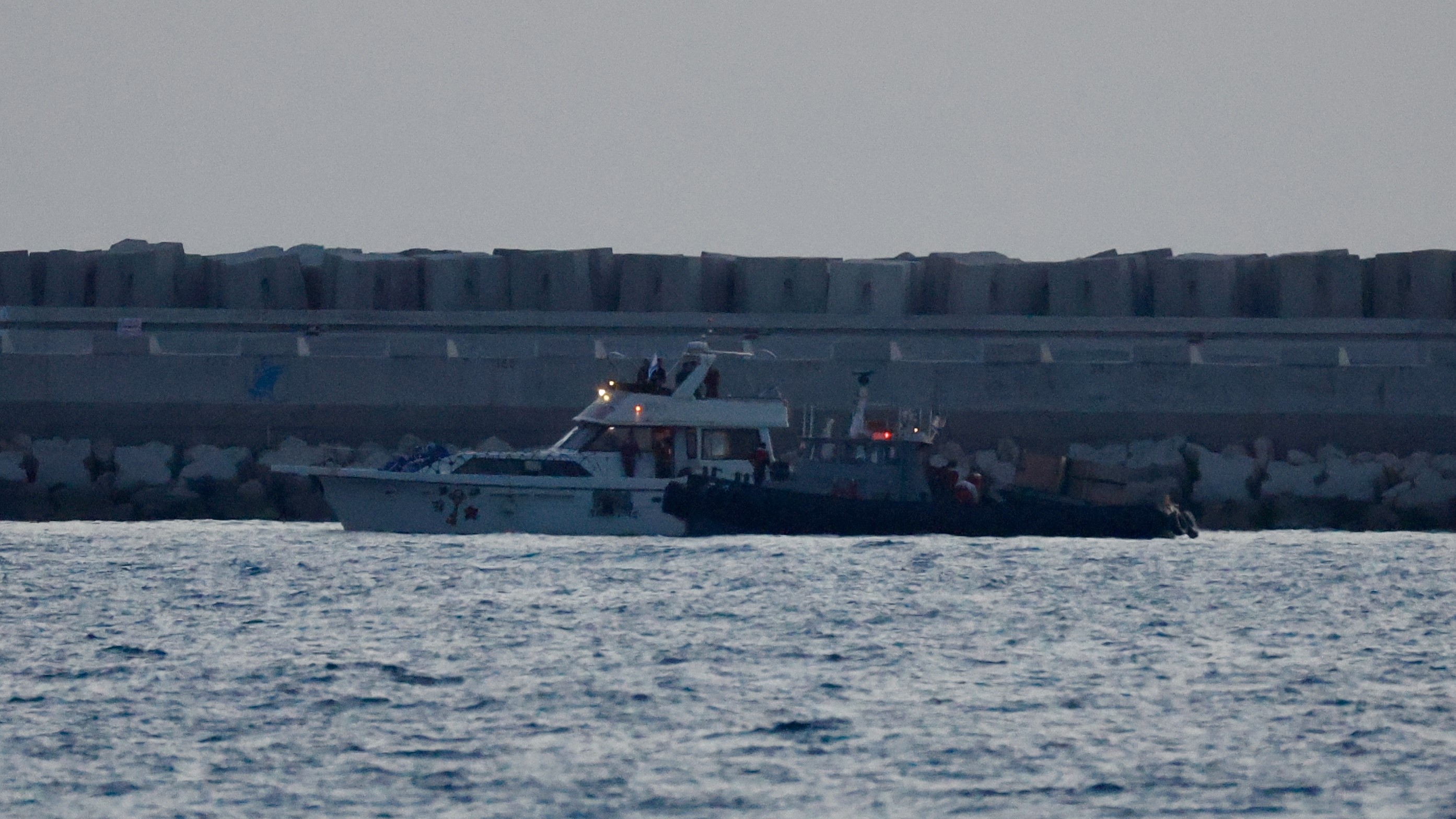 Unha das embarcacións da flotilla, escoltada por unha patrulleira israelí no porto de Ashdod (Europa Press / Contacto / Jamal Awad)