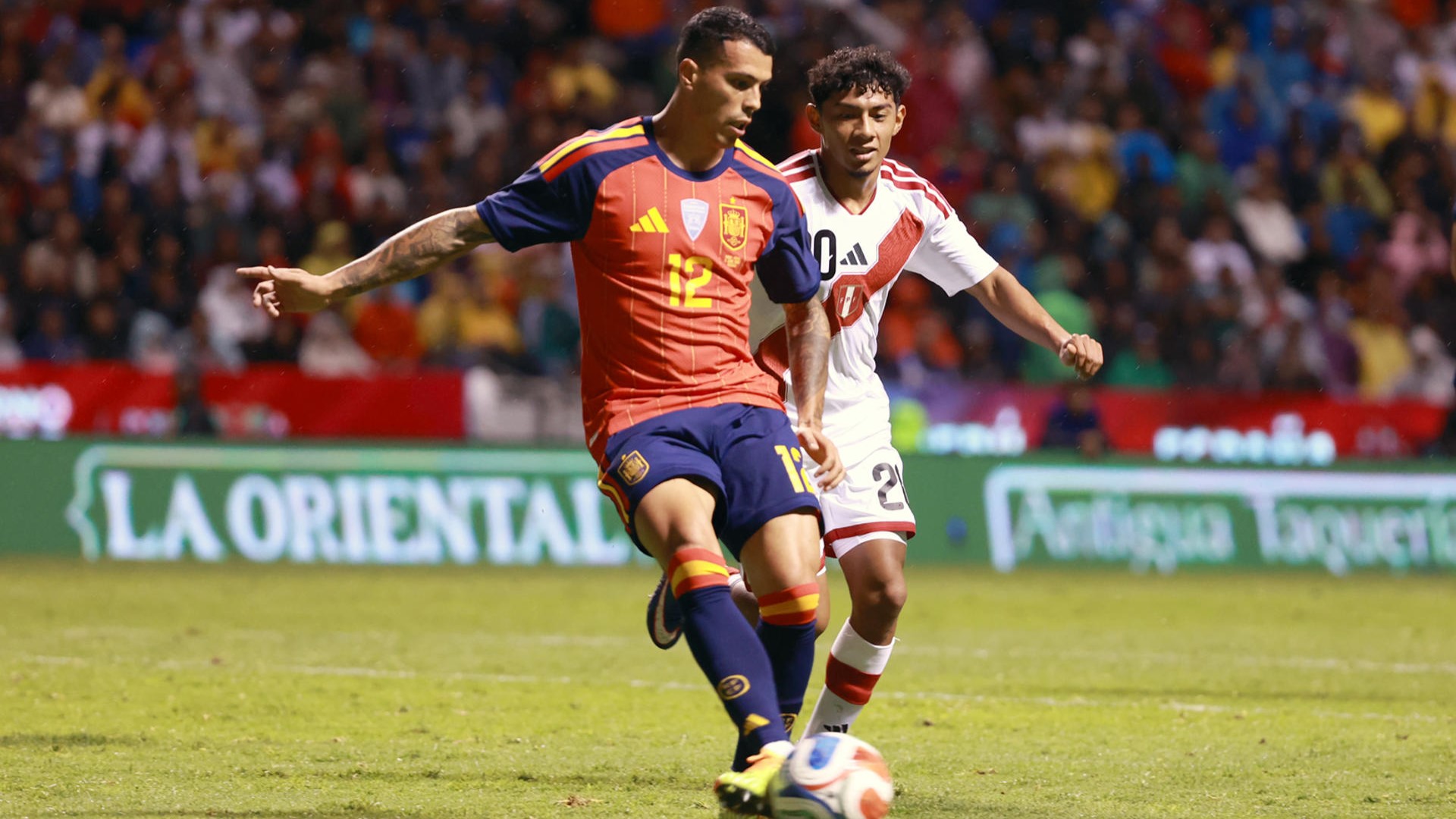 Pedro Porro (i) de España disputa un balón con Maxloren Castro do Perú este luns nun partido amigable entre España e Perú previo ao Mundial de Fútbol 2026 no estadio Cuauhtémoc en Puebla (México) EFE/ Alex Cruz