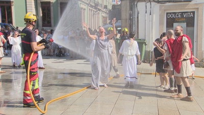 Un bombeiro refresca con auga unha romana na praza Maior de Lugo
