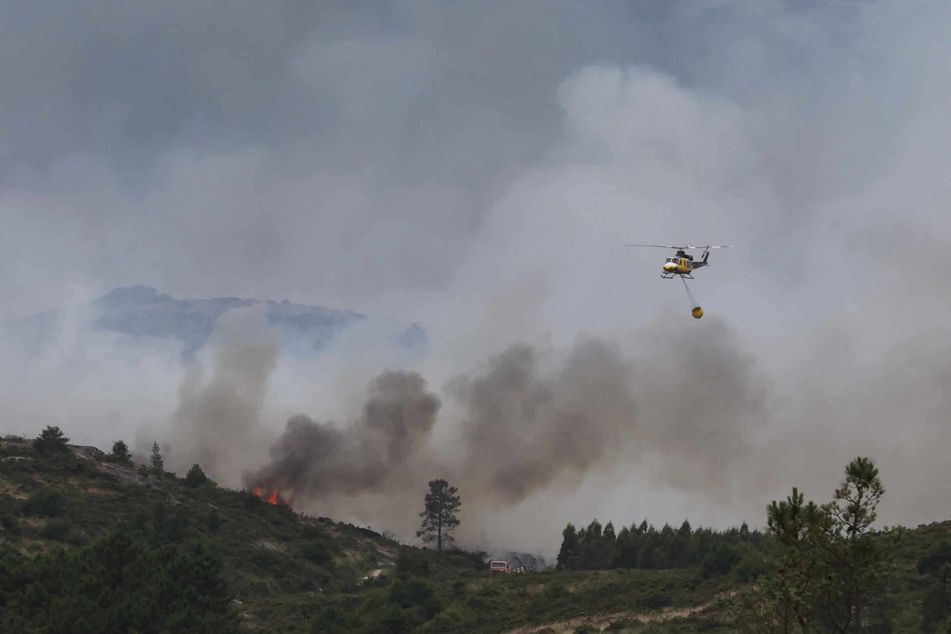Un helicóptero do servizo de extinción de incendios sobrevoa a zona alta do parque das Fragas do Eume, na Coruña, este martes. EFE/ Kiko Delgado
