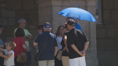 Un grupo de turistas procura a sombra no centro de Lugo
