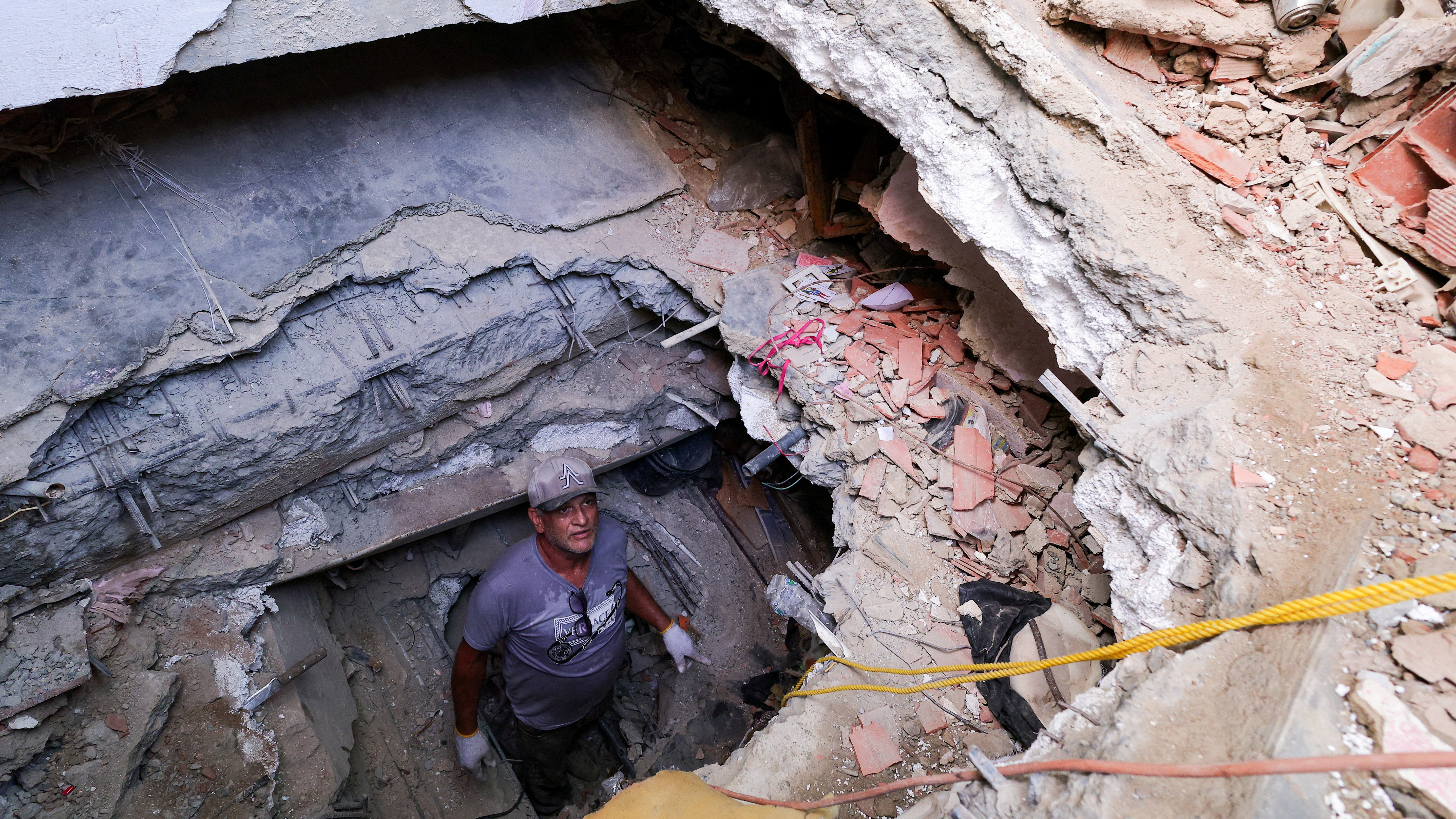 Un home fai un tunel para buscar os corpos da súa filla e o seu xenro en La Guaira. REUTERS/Gaby Oraa