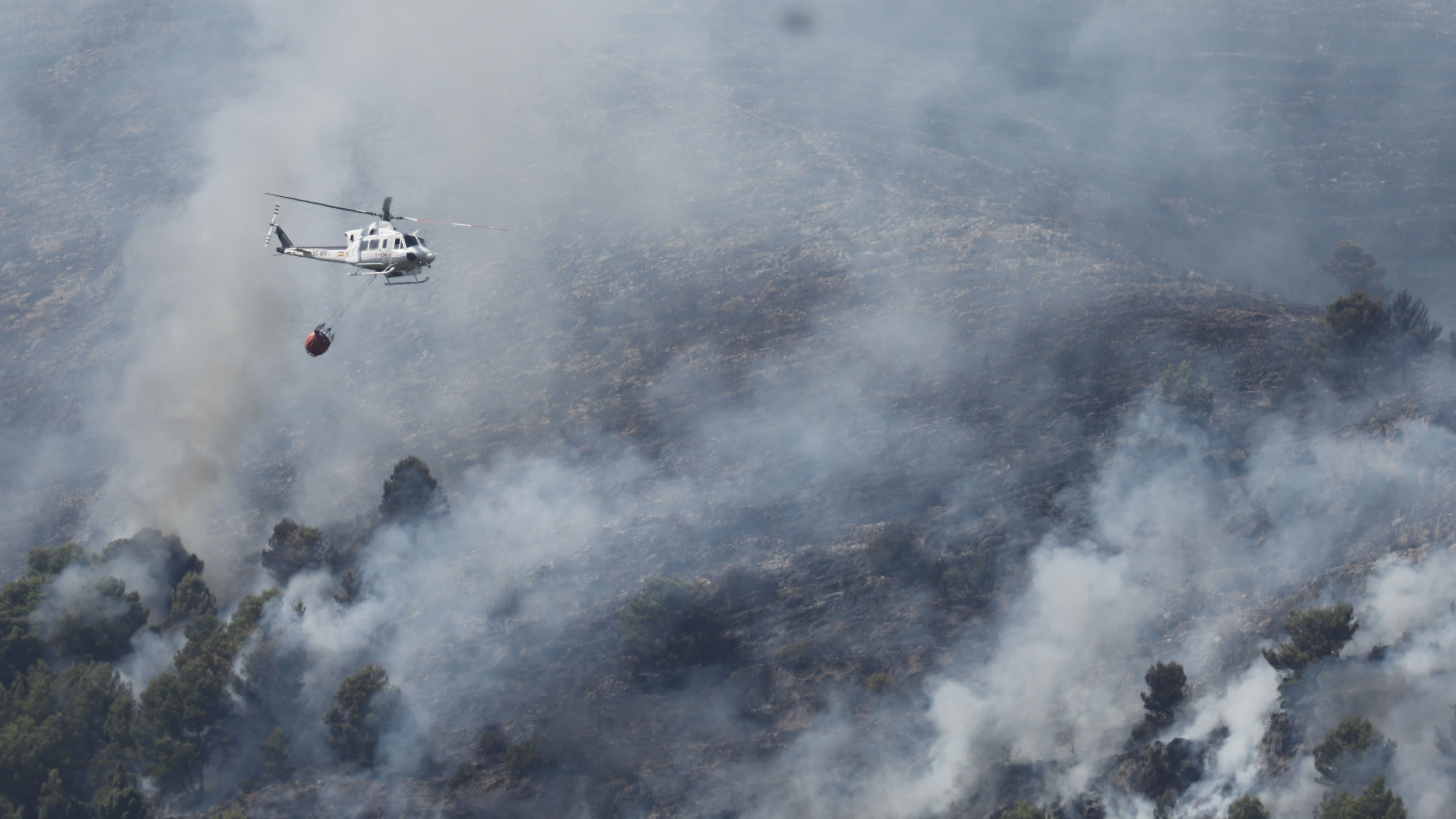 Un helicóptero traballa no incendio da Vall d'Uixò. Manuel Bruque/EFE