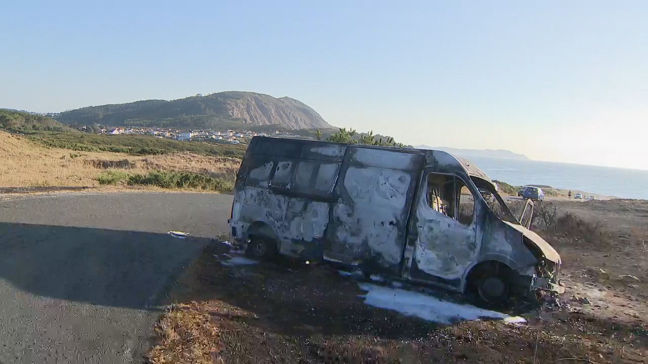 Furgoneta calcinada na estrada de acceso á praia dos Botes. TVG