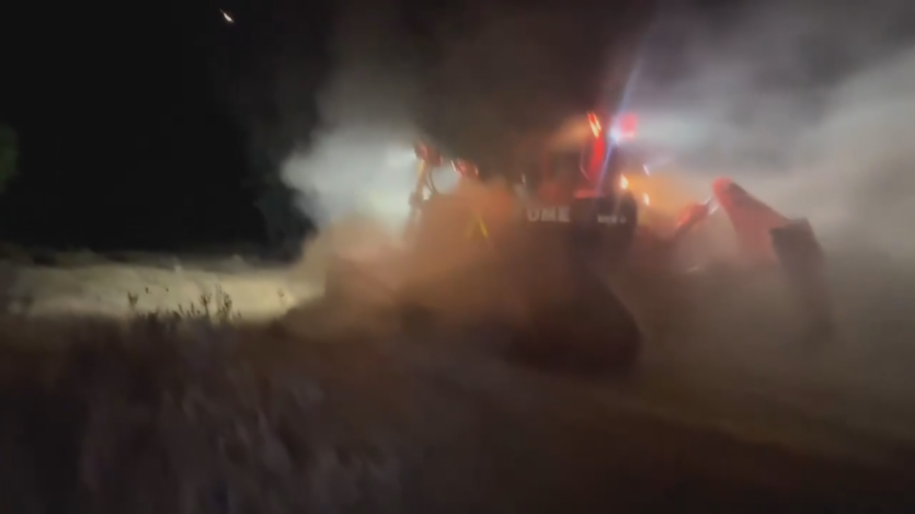 Un dos bulldozers da UME perimetrando do incendio. Imaxe: EFE