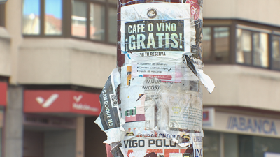 O poste dun farol cuberto de adhesivos nunha rúa do barrio do Calvario en Vigo.