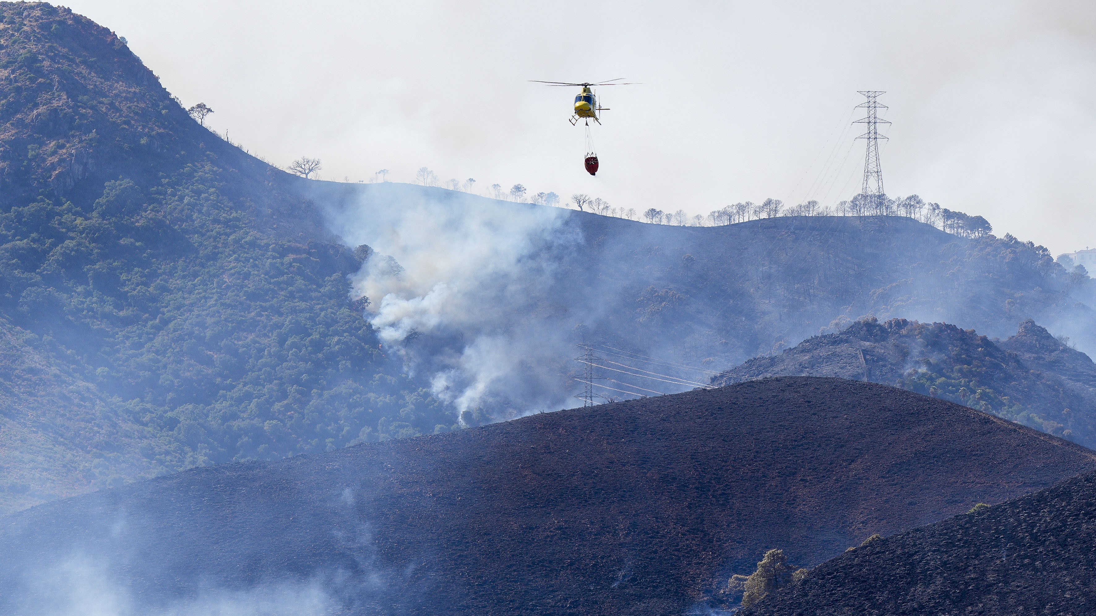 Un helicóptero na zona incendiada. EFE/Juan Carlos Domínguez