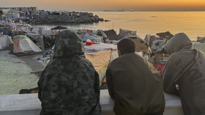 Migrantes na praia de Benitez, Ceuta, agardan o traslado as novas instalacións de acollida (EFE/Reduan)