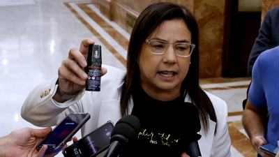 Ana Vázquez amosa o bote de gas pementa tras a súa expulsión do pleno (EFE/J.J. Guillen)