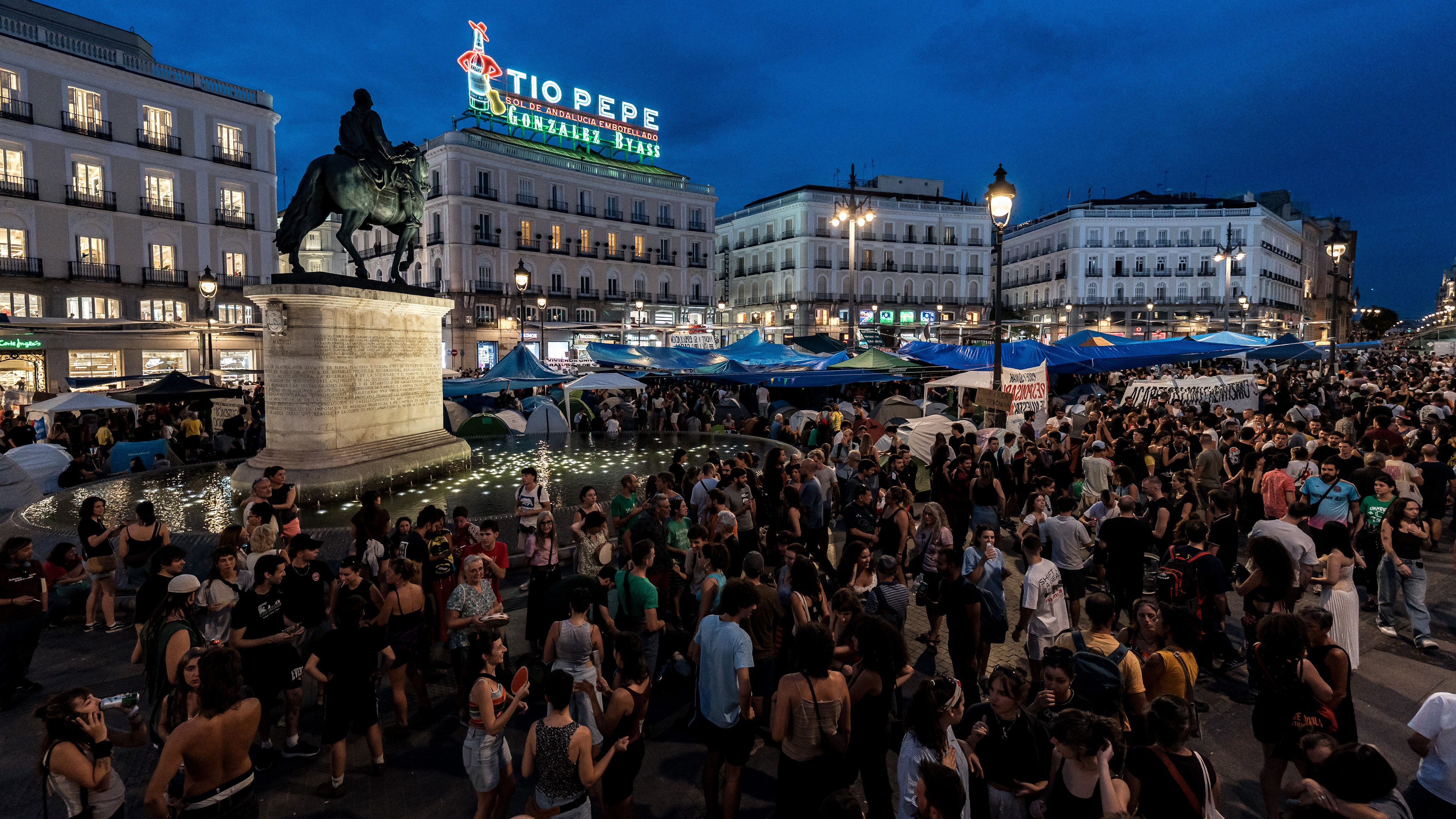 Centos de persoas pasan a segunda noite acampados en tendas de campaña na Porta do Sol para esixir a aprobación dun decreto sobre vivenda (Diego Radamés/Europa Press)