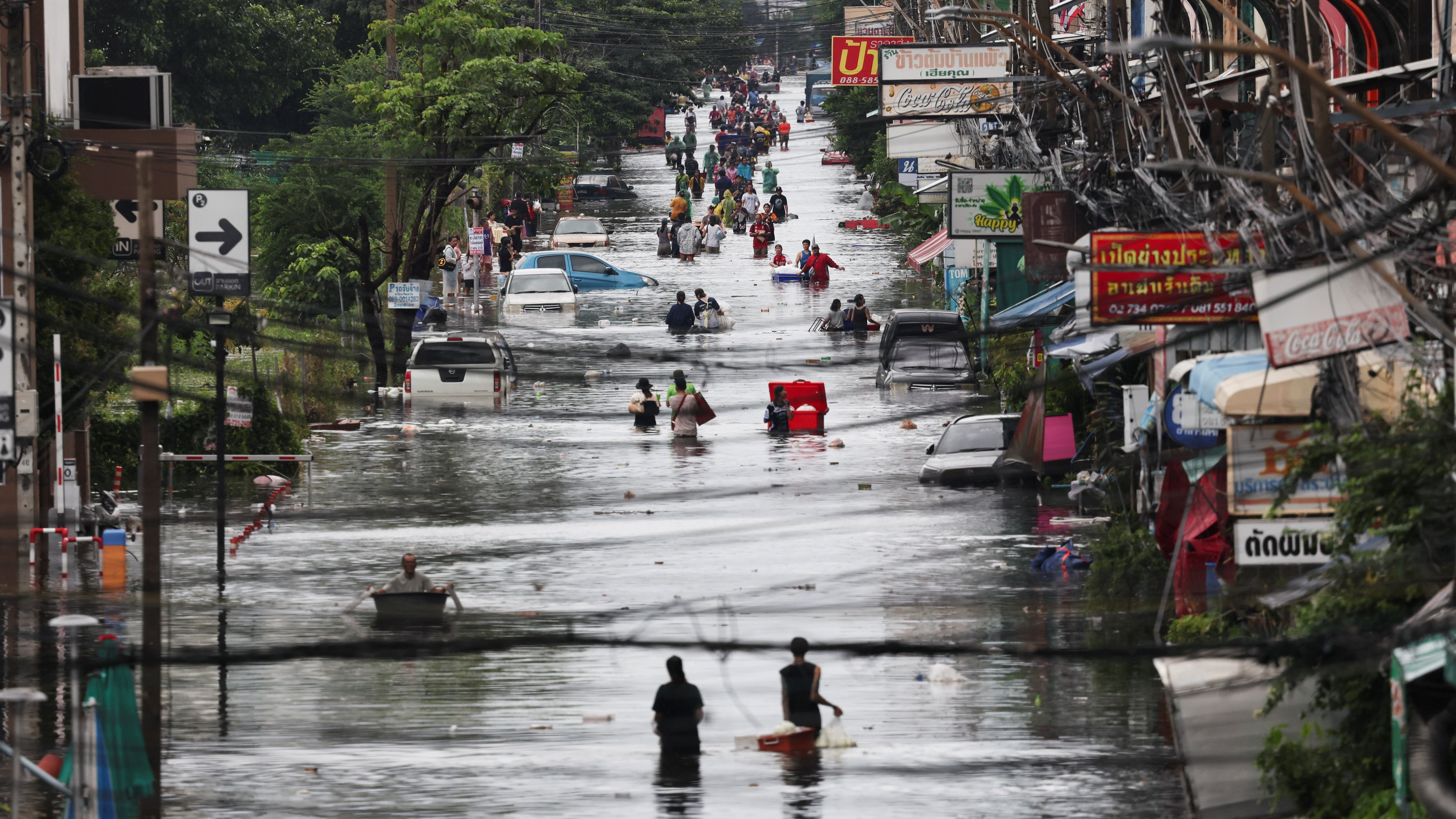 Ducias de persoas percorren as rúas inundadas de Bangkok (Reuters/Athit Perawongmetha)